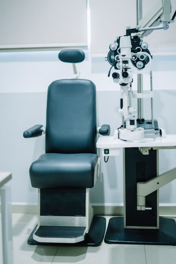 Modern eye exam room featuring an examination chair and advanced ophthalmic equipment.