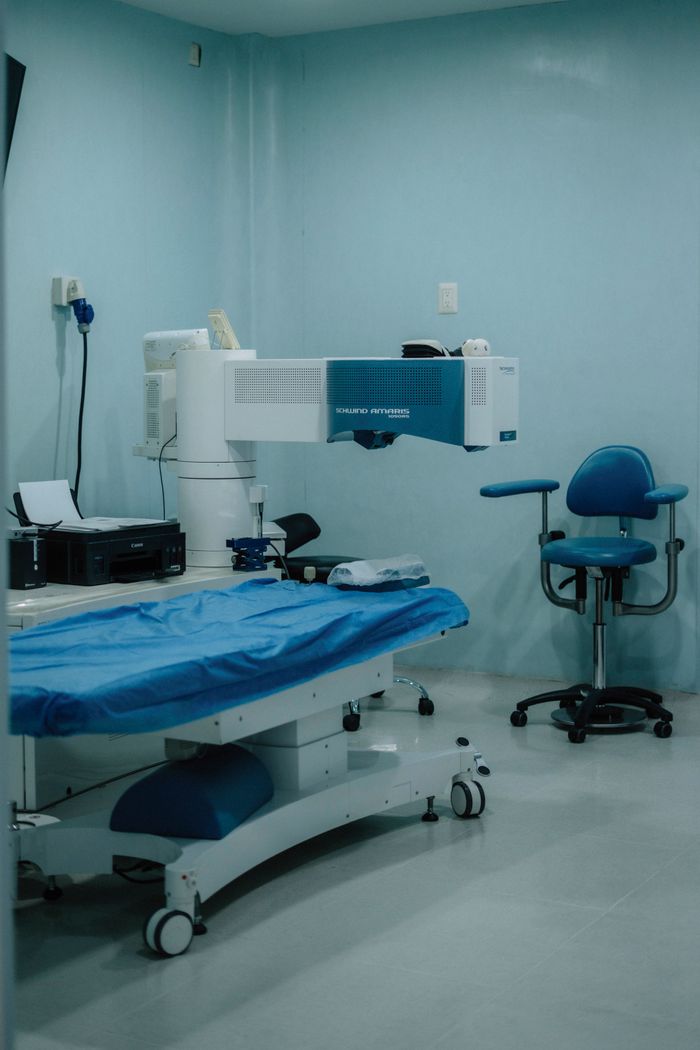 Interior view of a modern eye surgery operation room with specialized medical equipment and blue furnishings.